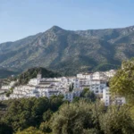 Illustrated whitewashed Andalusian hillside village below Sierra Blanca mountains
